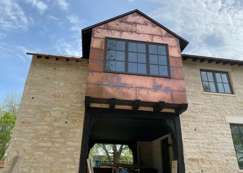 Copper metal panel facade on a stone building for Skylight Installation in Candlewick Lake